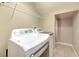 Laundry room features a washer and dryer set, metal rack, and neutral walls at 6782 Breezy Palm Dr, Riverview, FL 33578