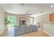 Bright living room with wood floors, a large gray sofa, and sliding doors opening to the outdoor space at 6782 Breezy Palm Dr, Riverview, FL 33578