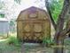 Image shows a barn with a gable roof and a double-door entrance, surrounded by lush greenery, offering a rustic, country charm at 7224 Ryman Loop, Zephyrhills, FL 33540