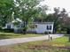 Charming single-story home with white siding, lush landscaping, and a concrete driveway at 7224 Ryman Loop, Zephyrhills, FL 33540