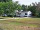 Charming single-story home with white siding, a cozy front porch, and a convenient carport, nestled amidst a lush green lawn at 7224 Ryman Loop, Zephyrhills, FL 33540