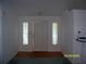 Welcoming foyer featuring a white front door, side windows, and neutral walls at 7224 Ryman Loop, Zephyrhills, FL 33540