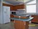 Functional kitchen featuring an island, wood cabinets, and standard appliances at 7224 Ryman Loop, Zephyrhills, FL 33540