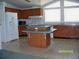 Functional kitchen with wood cabinets, an island, and a window-filled breakfast nook at 7224 Ryman Loop, Zephyrhills, FL 33540