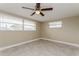 This bedroom offers lots of natural light with 2 windows and neutral paint and tile at 7405 Oakshire Dr, Port Richey, FL 34668