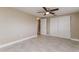 A bright bedroom has neutral paint, tile floors, ceiling fan, and closet with sliding doors at 7405 Oakshire Dr, Port Richey, FL 34668