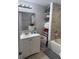 Bathroom with a white vanity, sink, large mirror, stacked storage and a tub-shower with gray tile surround at 7525 Arbordale Dr, Port Richey, FL 34668