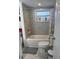 Bright bathroom featuring a tub with gray tiling and a light floral shower curtain and a toilet at 7525 Arbordale Dr, Port Richey, FL 34668