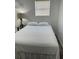 Cozy bedroom featuring a comfortable bed with clean, white linens and a stylish lamp on a glass side table at 7525 Arbordale Dr, Port Richey, FL 34668