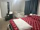 Spacious bedroom featuring a crib, seating, large closet, and bright patterned bedding at 7525 Arbordale Dr, Port Richey, FL 34668