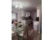 Bright kitchen with modern chandelier, white cabinets, granite countertops, and hardwood flooring at 7525 Arbordale Dr, Port Richey, FL 34668
