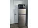 Kitchen featuring stainless steel retro refrigerator with microwave on top, next to a white door at 7525 Arbordale Dr, Port Richey, FL 34668
