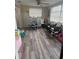 Bright sitting room with hardwood flooring, multiple chairs, toys, and natural light from window at 7525 Arbordale Dr, Port Richey, FL 34668