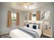 Comfortable bedroom featuring a ceiling fan, two windows with neutral curtains, and light wood floors at 7529 35Th N Ave, St Petersburg, FL 33710