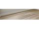 Close up of light colored wood-grain flooring with white base trim along the wall at 8514 Dove Bog Ter, Parrish, FL 34219