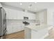 Modern kitchen featuring white cabinets, stainless steel appliances, and a center island with a quartz countertop at 8514 Dove Bog Ter, Parrish, FL 34219