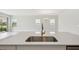 Kitchen island with stainless sink and modern faucet, with a spacious living area in the background at 8514 Dove Bog Ter, Parrish, FL 34219