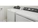 Laundry room featuring modern, front-loading washer and dryer with black control panels at 8514 Dove Bog Ter, Parrish, FL 34219
