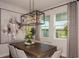 Dining room features a modern chandelier, neutral walls, and a view to the backyard at 10009 Surrey Rose Dr, San Antonio, FL 33576