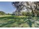 View of the property from an expansive backyard featuring mature trees and a lush green lawn at 1089 Virginia St, Dunedin, FL 34698