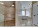 Luxurious bathroom featuring a glass shower, soaking tub, and neutral stone tiling at 1089 Virginia St, Dunedin, FL 34698