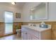 Bright bathroom featuring a white vanity, a frosted window for privacy, and travertine tile wainscoting at 1089 Virginia St, Dunedin, FL 34698
