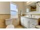 Bright bathroom with window, toilet, vanity, sink and mirror at 1089 Virginia St, Dunedin, FL 34698