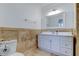 Well-lit bathroom featuring a vanity with white cabinets and a matching mirror at 1089 Virginia St, Dunedin, FL 34698