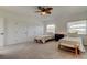 Spacious bedroom with two twin beds, bench seating, ceiling fan, and neutral carpeting at 1089 Virginia St, Dunedin, FL 34698