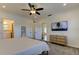 Bright bedroom features an ensuite bathroom, a TV, ceiling fan, and neutral furnishings at 1089 Virginia St, Dunedin, FL 34698