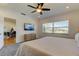 Bright bedroom features a large window, a ceiling fan, plush carpet flooring, and a TV at 1089 Virginia St, Dunedin, FL 34698