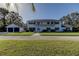 Charming two-story home with a balcony, dark shutters and a two-car garage on a manicured lawn at 1089 Virginia St, Dunedin, FL 34698