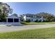 Two-story home with a balcony, dark shutters, two-car garage and driveway situated on a well-kept lawn at 1089 Virginia St, Dunedin, FL 34698