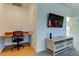 Versatile bonus room with built-in desk, mounted TV, and carpet flooring, perfect for a home office at 1089 Virginia St, Dunedin, FL 34698