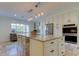 Kitchen island with stainless steel appliances, granite countertops, white cabinetry, and pendant lighting at 1089 Virginia St, Dunedin, FL 34698