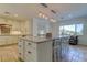 Open kitchen featuring a large island with bar seating, granite countertops and modern lighting fixtures at 1089 Virginia St, Dunedin, FL 34698