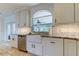 Kitchen featuring a farmhouse sink, granite countertops, stainless dishwasher and custom cabinetry at 1089 Virginia St, Dunedin, FL 34698