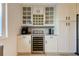 Kitchen coffee bar with wine refrigerator, beverage cooler, granite counters, and custom cabinetry at 1089 Virginia St, Dunedin, FL 34698
