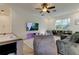 Comfortable living area with an air hockey table and plush seating, illuminated by a ceiling fan and natural light at 1089 Virginia St, Dunedin, FL 34698