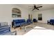 Covered patio with modern furniture, large windows, and ceiling fan at 1089 Virginia St, Dunedin, FL 34698