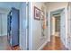 Hallway featuring hardwood floors, white doors, and stylish decorations leading to a bathroom at 1111 Normandy Trace Rd # 1111, Tampa, FL 33602