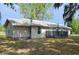 The home has neutral siding, a metal roof, and a small front porch at 11141 Rex Hunter Ln, Lithia, FL 33547