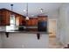 Warm kitchen features wood cabinets, granite countertops, a breakfast bar, and black appliances at 11141 Rex Hunter Ln, Lithia, FL 33547