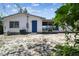 Back exterior of a home with a blue door, utility connections and screened porch at 11409 Spring Hill Dr, Spring Hill, FL 34609