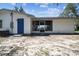 An exterior shot of the rear of the home showcasing the backyard and screened in porch at 11409 Spring Hill Dr, Spring Hill, FL 34609