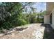 Backyard featuring natural landscape with trees, grass, and an exterior of the home in background at 11409 Spring Hill Dr, Spring Hill, FL 34609