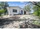Exterior view showcasing the backyard, the white siding, and a blue door on a sunny day at 11409 Spring Hill Dr, Spring Hill, FL 34609