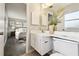Bright bathroom with white cabinets, sink, toilet and large mirror, and bedroom view at 11409 Spring Hill Dr, Spring Hill, FL 34609