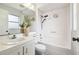 Bright bathroom featuring white sink, toilet, shower and mirror with natural light at 11409 Spring Hill Dr, Spring Hill, FL 34609