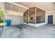 Spacious carport featuring open-air and screened-in sections, with access to a blue exterior door at 11409 Spring Hill Dr, Spring Hill, FL 34609